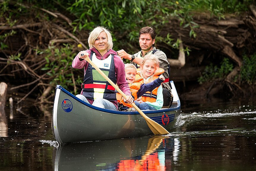 Dieses Bild zeigt eine Familie, die auf den Bildebetrachter zu paddelt.