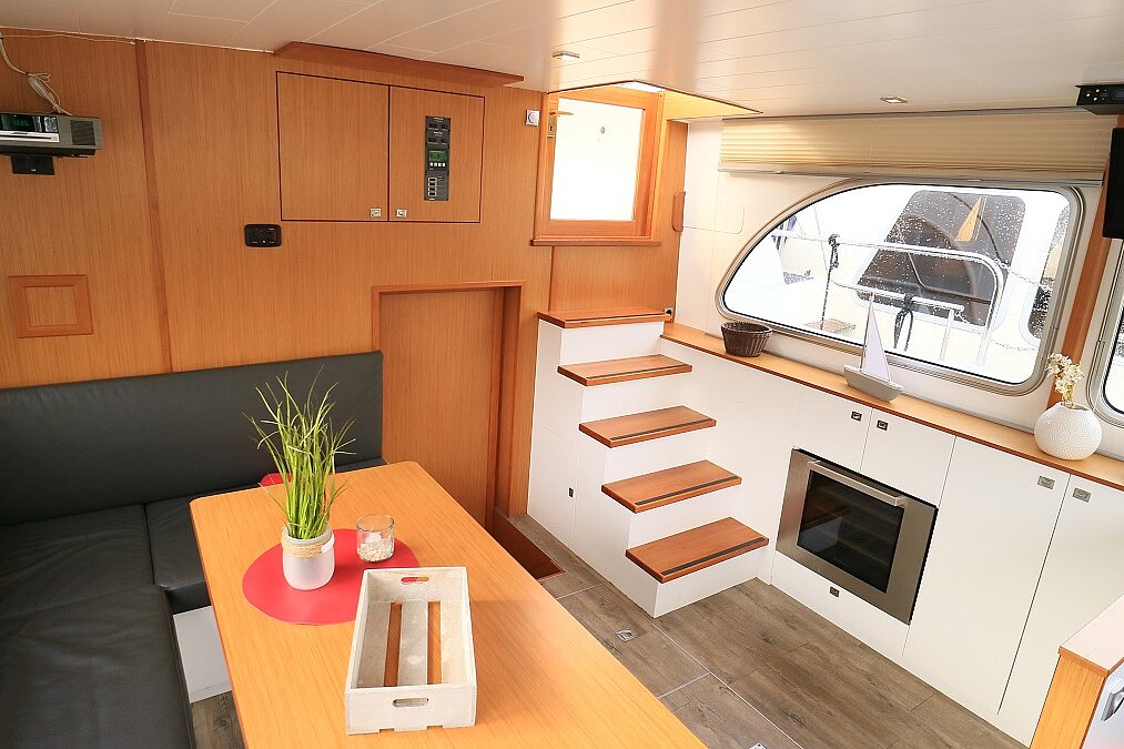 Dieses Bild zeigt unsere Yacht Platinum - M-Retro 120 - Salonansicht Tisch und Schrankwand