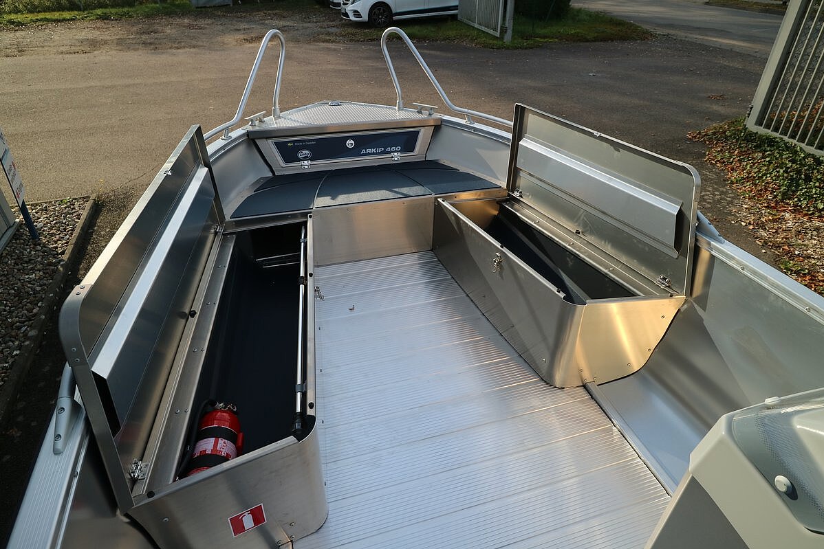 Dieses Bild zeigt eine komplette Sitzflächenreihe mit zwei geöffneten Staurraumklappen.