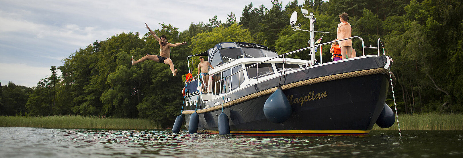 Eine Person springt von einer unserer Yachten.