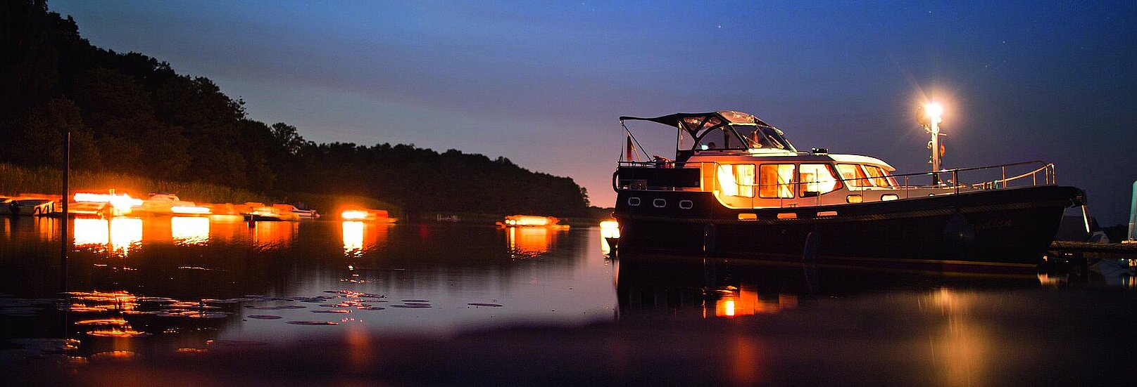 eine unserer Yachten bei Abenddämmerung auf dem Wasser 