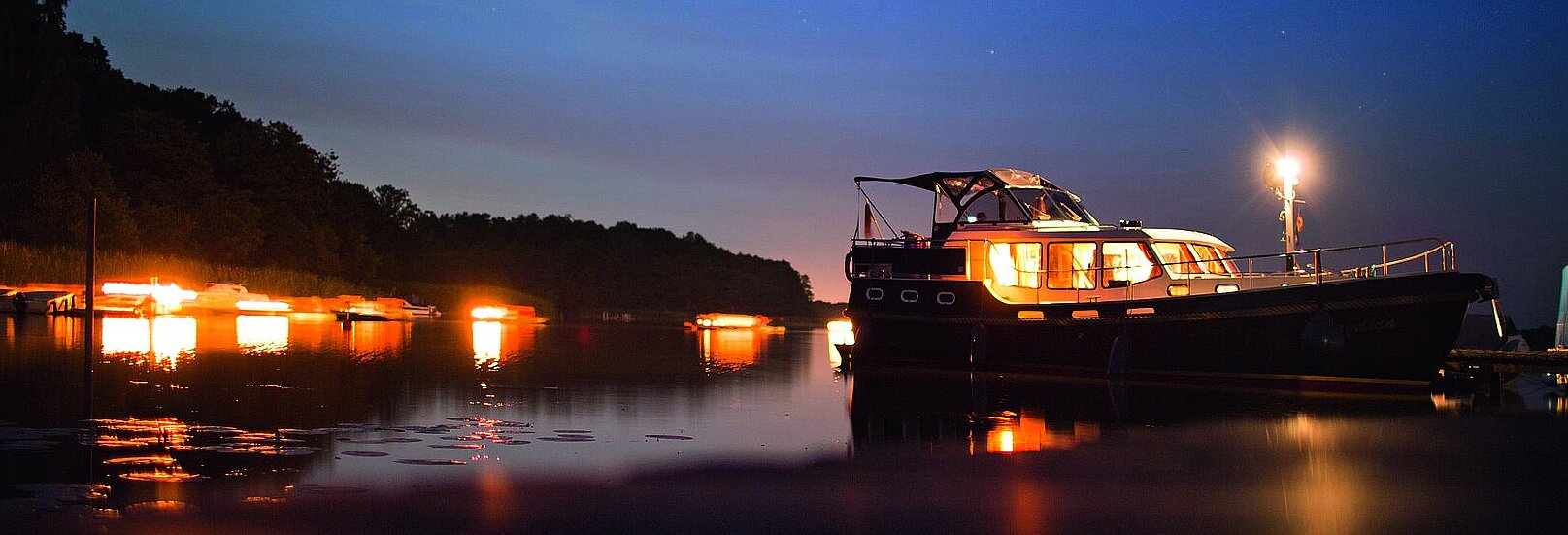 eine unserer Yachten bei Abenddämmerung auf dem Wasser 