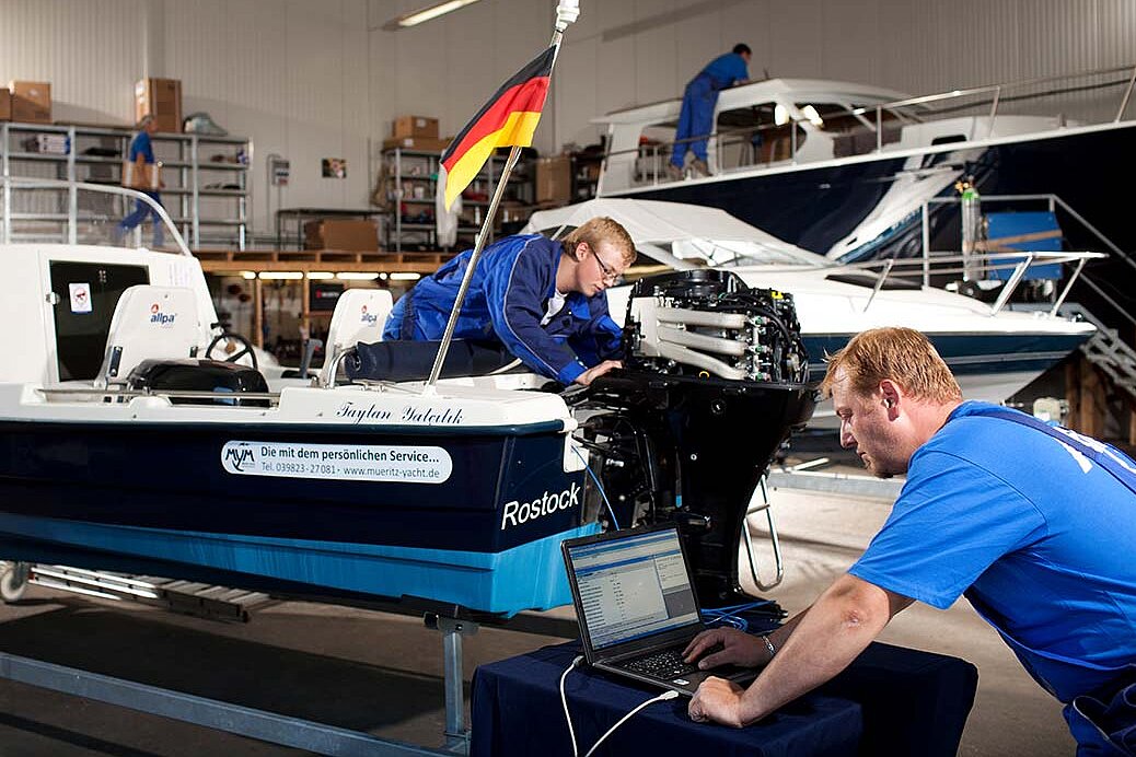 Unsere Mitarbeiter bei der Reparatur eines Bootsmotors
