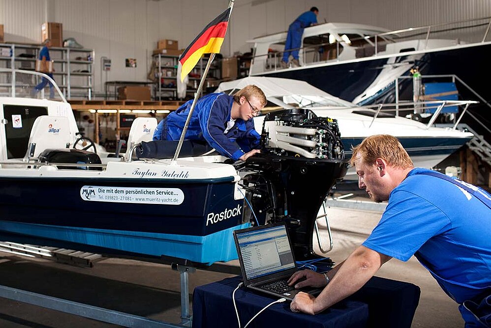 Unsere Mitarbeiter bei der Reparatur eines Bootsmotors