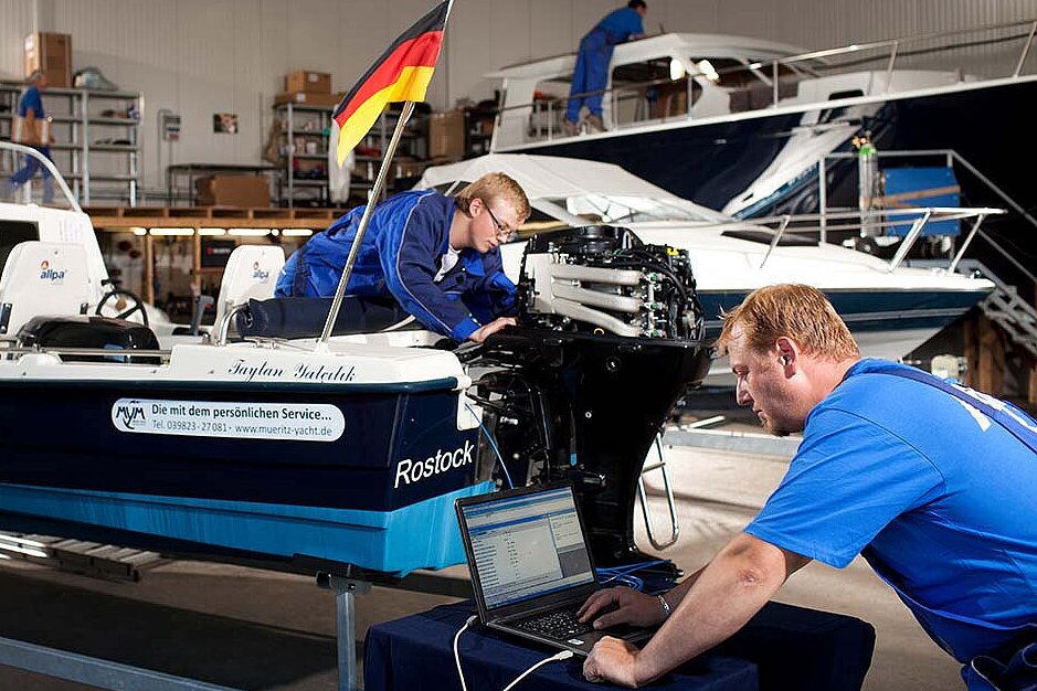 Unsere Mitarbeiter bei der Reparatur eines Bootsmotors