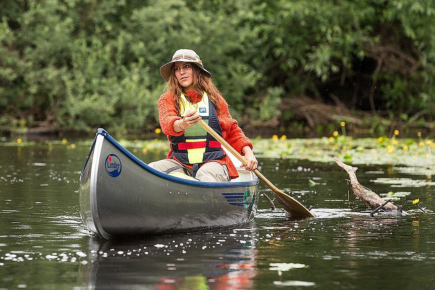 Dieses Bild zeigt eine Frau im Kanu auf dem Wasser.