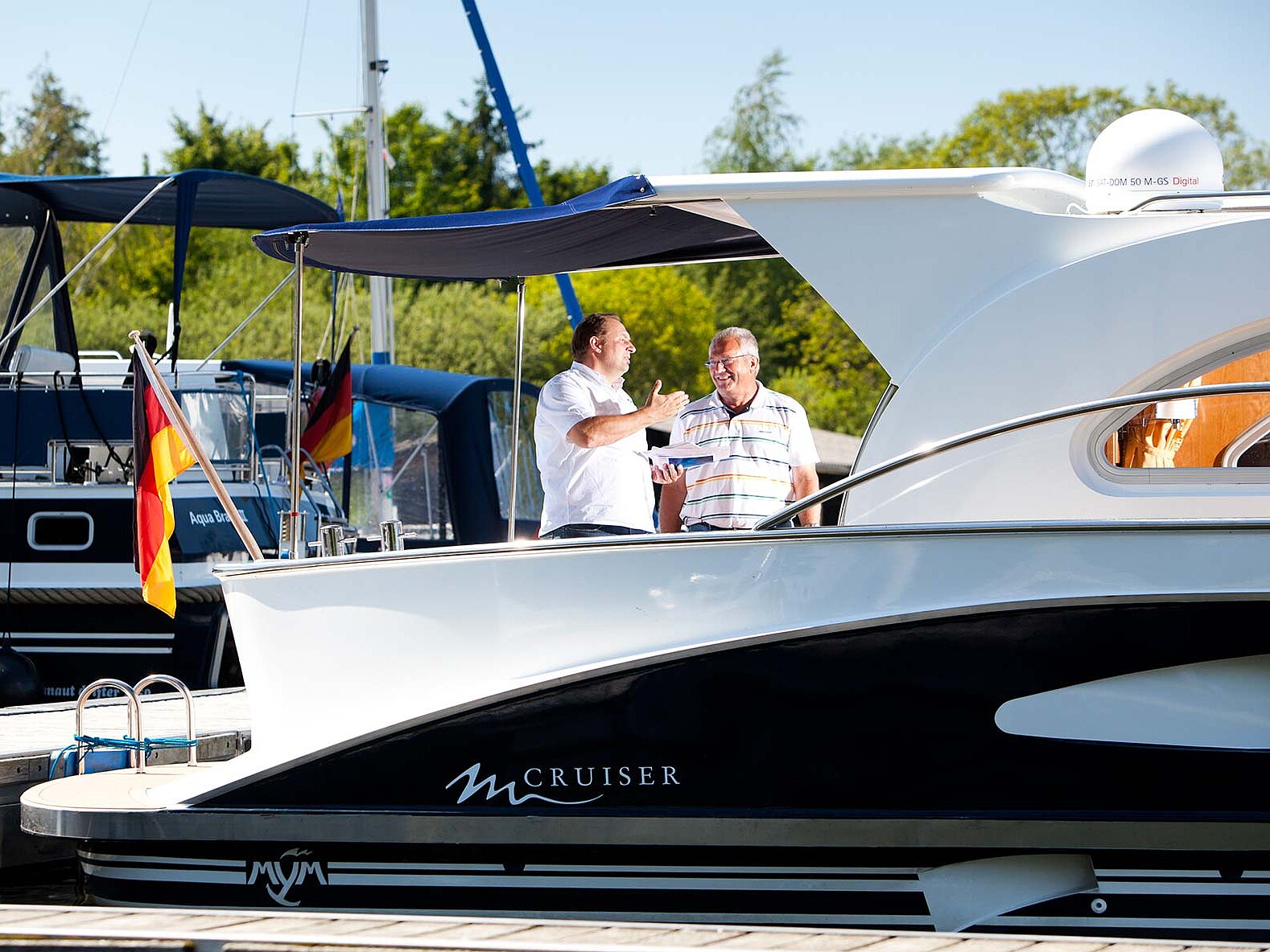 Ein Mitarbeiter berät einen Kunden auf einer Yacht.