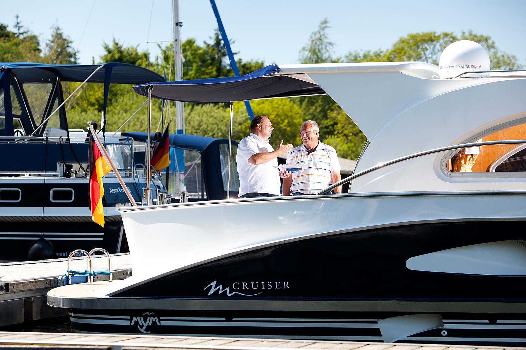Zwei Personen stehen auf einer unserer Yachten und unterhalten sich