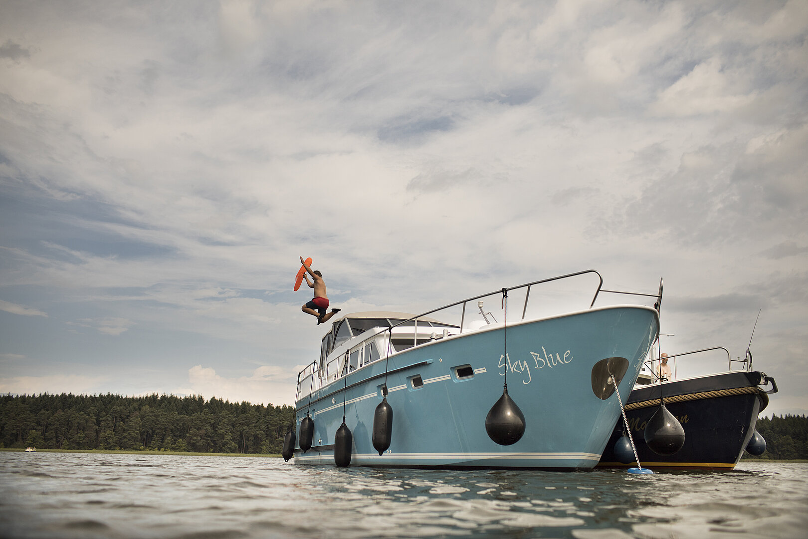 Auf diesem Bild sehen sie eine unserer Yachten, von dieser spring gerade eine Person ins Wasser
